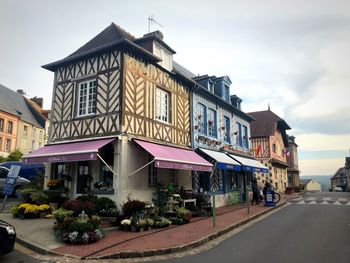 Street by buildings in town against sky