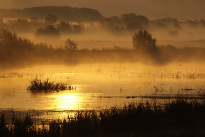 Scenic view of lake against sky during sunset