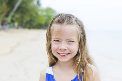 Close-up portrait of smiling girl at beach