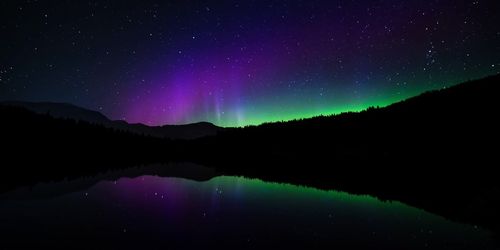 Scenic view of lake against sky at night