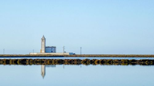 View of lake against clear blue sky