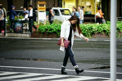 Rear view of woman standing on city street