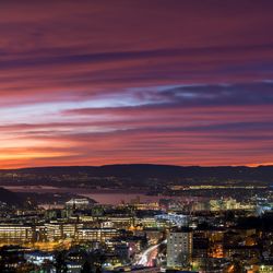 High angle view of illuminated city against sky at sunset