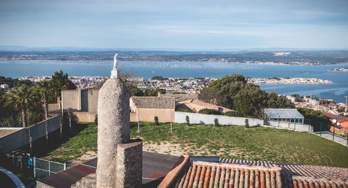 High angle view of townscape by sea against sky