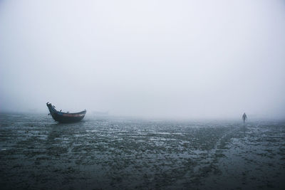 Lone boat in calm sea against sky