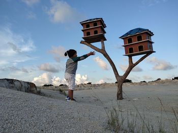 Full length of boy standing on land against sky