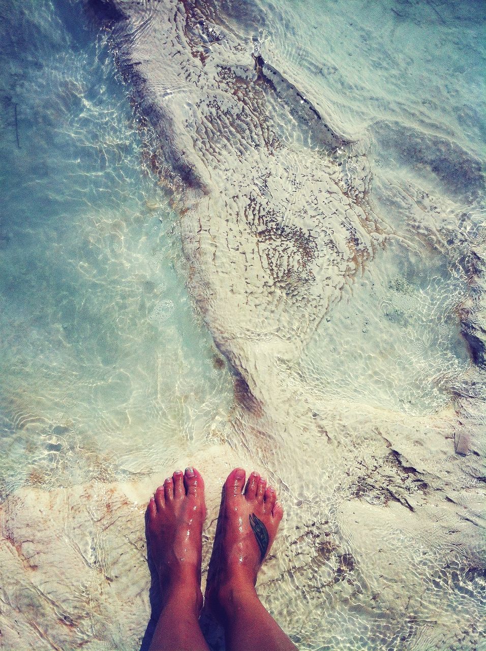 low section, person, personal perspective, water, human foot, beach, sand, sea, high angle view, barefoot, shore, unrecognizable person, leisure activity, lifestyles, standing, vacations, nature