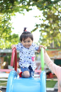 Portrait of smiling girl playing on slide
