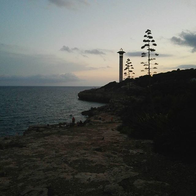 sea, guidance, lighthouse, sky, water, horizon over water, direction, built structure, rock - object, communication, architecture, nature, tranquility, tranquil scene, scenics, cloud - sky, building exterior, beauty in nature, outdoors, beach