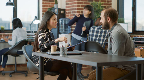 Young woman using laptop at cafe