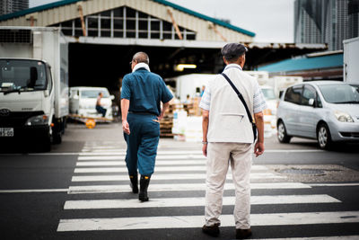 Rear view of woman standing on road