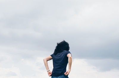 Rear view of woman standing against sky