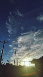 Low angle view of silhouette electricity pylon against sky