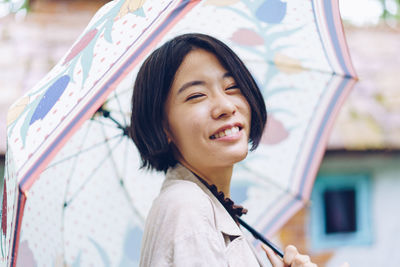 Portrait of a smiling young woman in rain