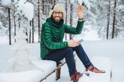 Portrait of young man using mobile phone during winter