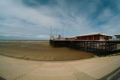 Pier on beach against sky