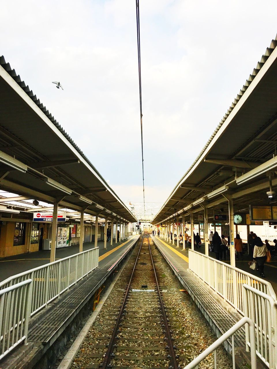 TRAIN ON RAILROAD STATION AGAINST SKY