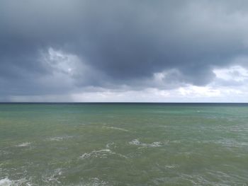 Scenic view of sea against storm clouds