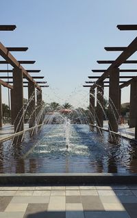 Water fountain in swimming pool against sky