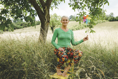 Portrait of young woman standing on field