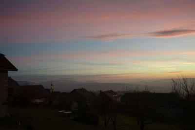 Houses against sky during sunset