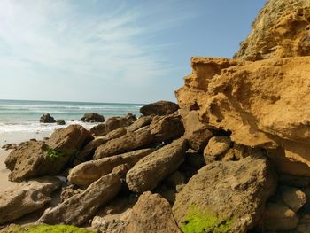 Rocks on beach against sky