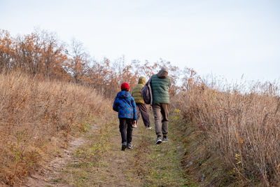 Rear view of man walking on field
