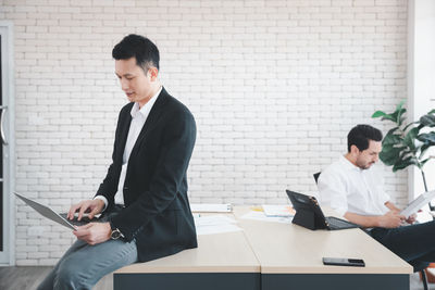 Young man using mobile phone in office