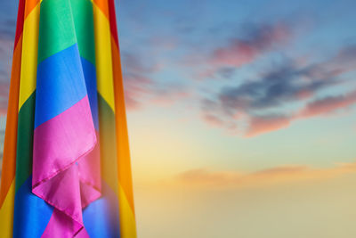 Close-up of multi colored flags against sky during sunset