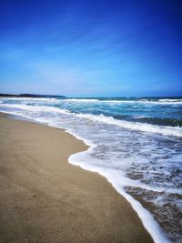 Scenic view of beach against blue sky