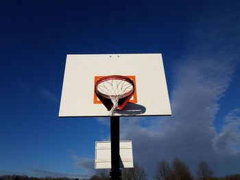 Low angle view of basketball hoop against blue sky