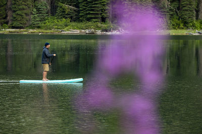 Man standing by lake in forest