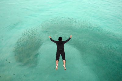 Full length rear view of man in sea