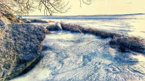 Scenic view of frozen lake against sky during winter