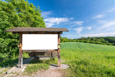 Built structure on field by trees against sky