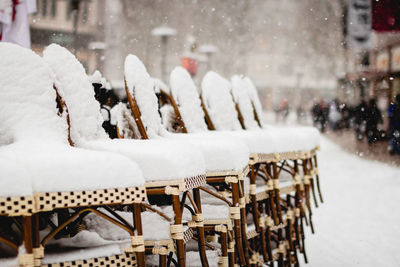 Snow covered chairs outdoors during winter