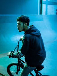 Side view of young man riding bicycle