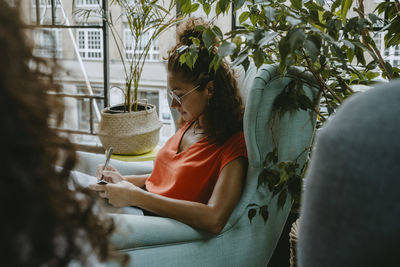 Side view of woman holding potted plant