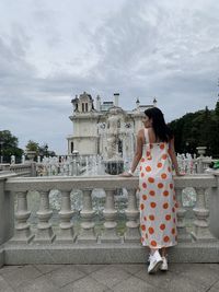 Rear view of woman standing against sky