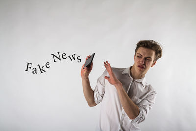 Young man with text standing against white background