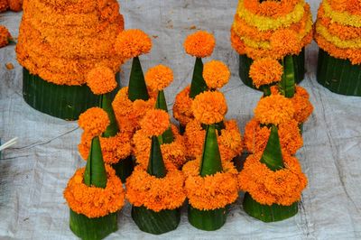 High angle view of religious offerings made from marigold flowers and banana leaves