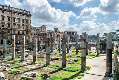 Ancient ruins in rome, italy. summer wide angle view of old buildings against cloudy blue sky.