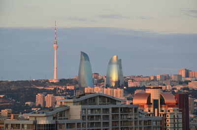 Buildings in city against cloudy sky