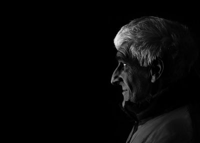 Portrait of man against black background