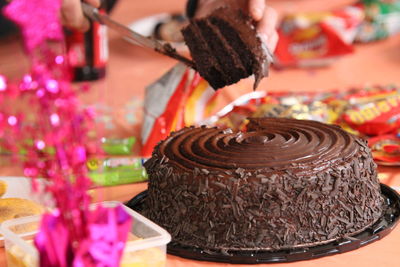 Close-up of hand holding chocolate cake