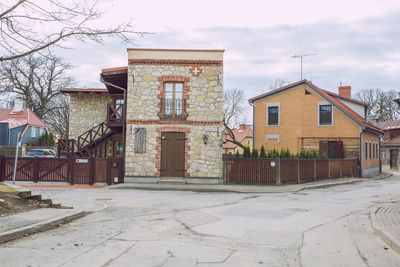 Houses by street against sky in city