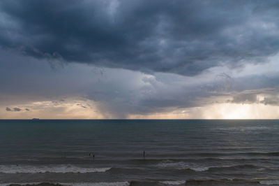 Scenic view of beach against cloudy sky