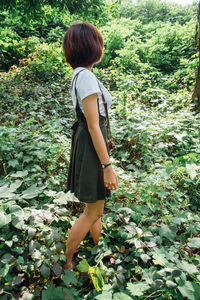 Rear view of woman standing amidst plants