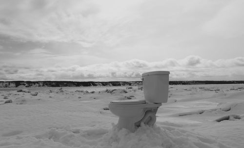 Abandoned commode on snow covered landscape