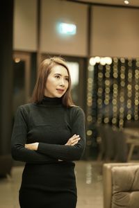 Beautiful woman looking away while standing indoors